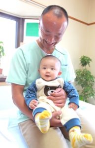 赤ちゃんを抱っこする院長